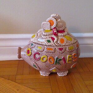 Vintage pig shaped cookie jar with cookies piled on top, nose and eyes resemble